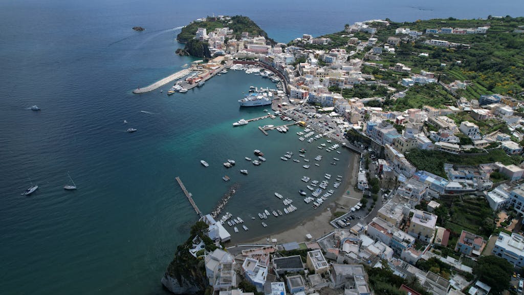 Sailing in the Pontine Islands 1 A stunning aerial view of Ponza Island harbor with boats and coastal town in summer.