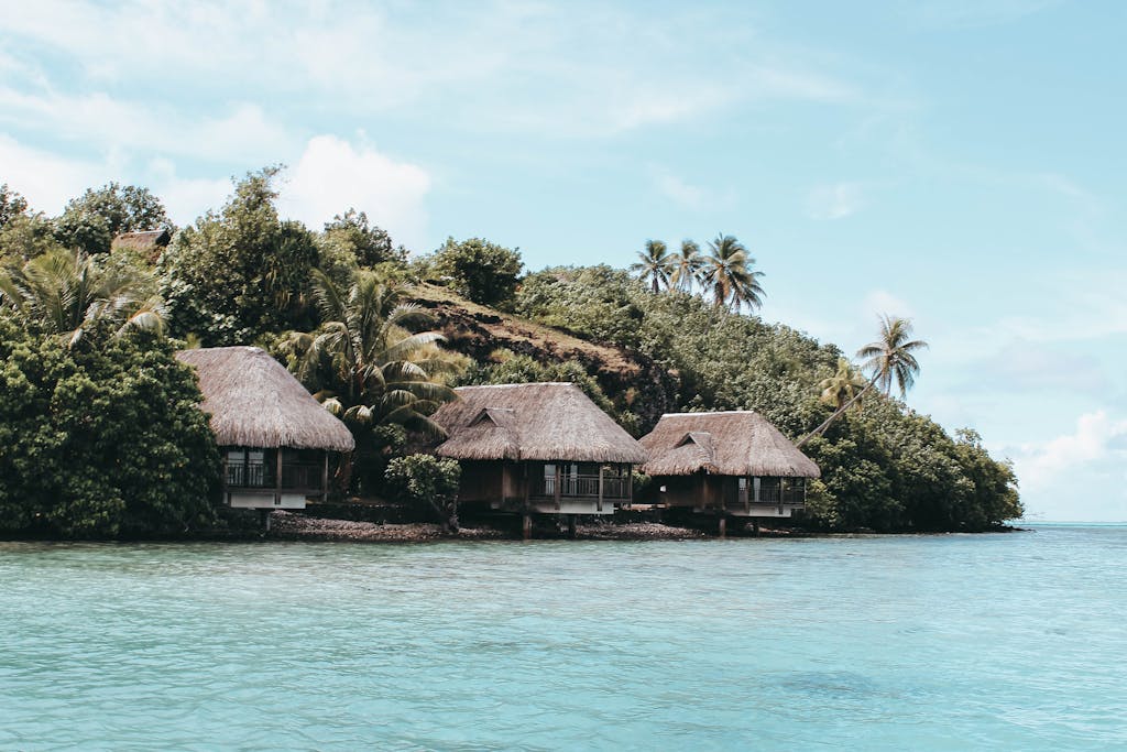 Idyllic overwater bungalows with lush greenery and turquoise waters in French Polynesia.