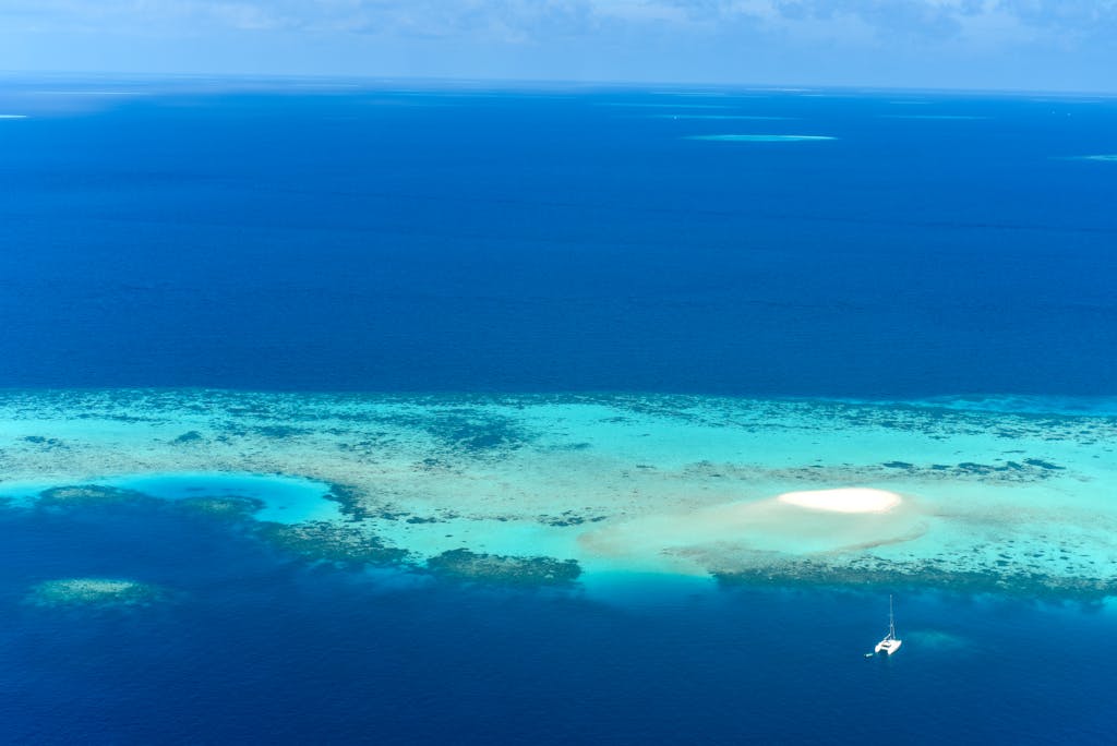A stunning aerial view of a tropical island in southeast asia surrounded by turquoise waters and coral reefs.