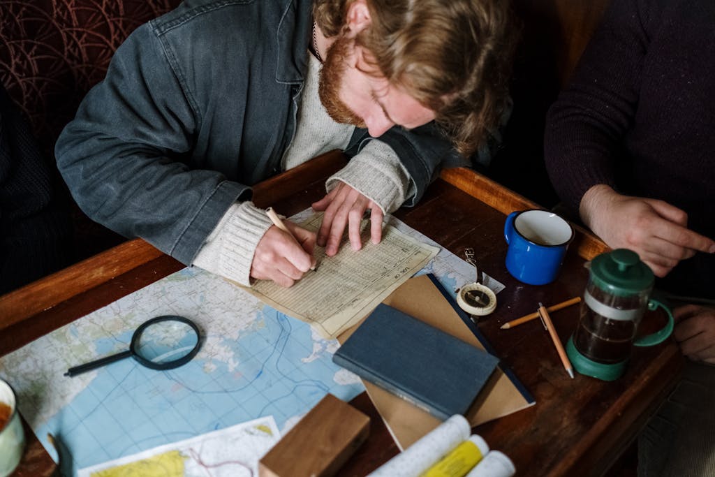Adult man focused on sketching nautical plans at a cozy wooden table.