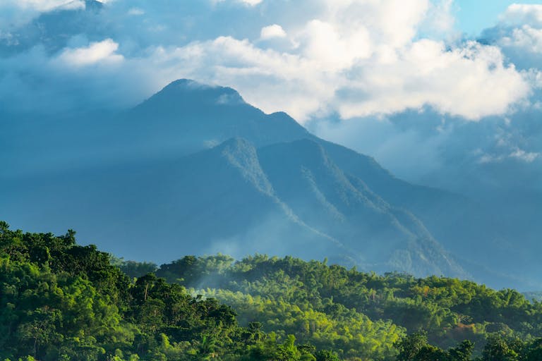 Serene view of the Blue Mountains in Jamaica, shrouded in clouds and sunlight.