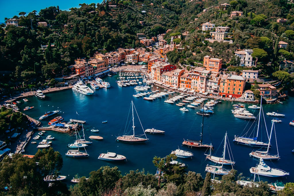 A stunning aerial view of Portofino harbor, showcasing yachts and colorful buildings in sunny Italy.