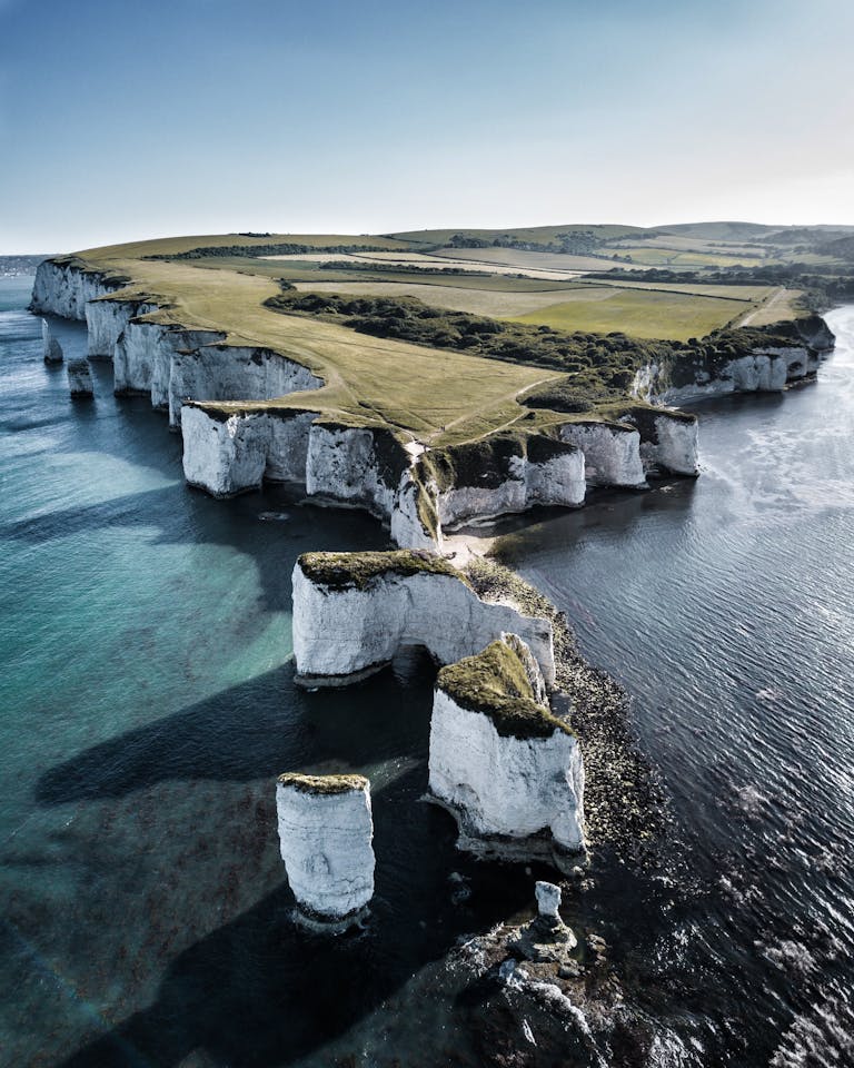 Breathtaking aerial view of England's scenic Old Harry Rocks on a sunny day.