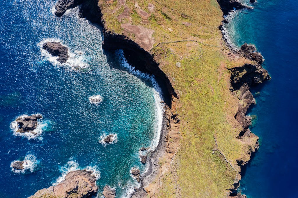 Breathtaking aerial view of Madeira's coastline with rocky formations and blue ocean.