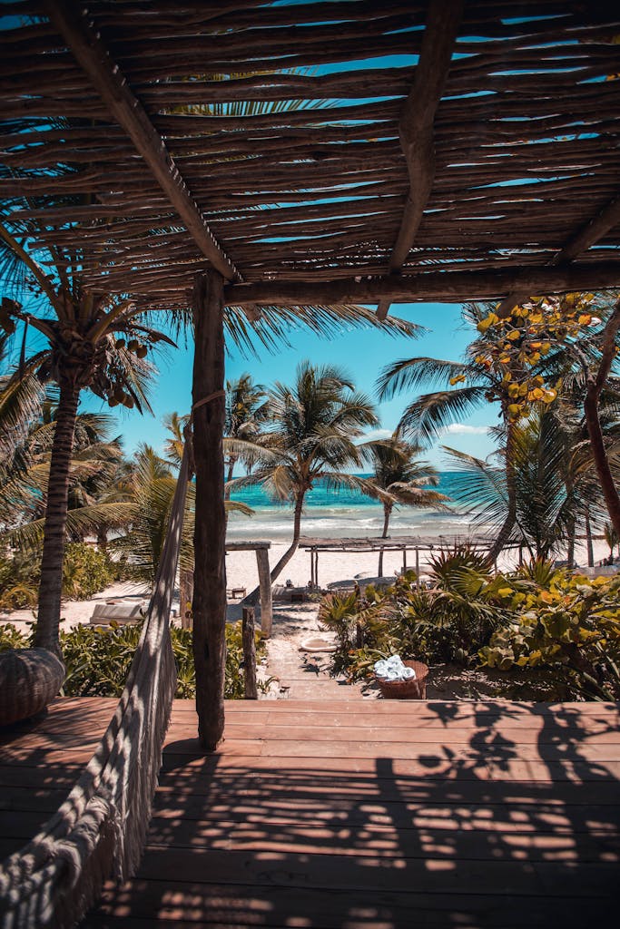 Explore a serene beachfront view with palm trees in Tulum, Mexico. Perfect for travel and leisure.