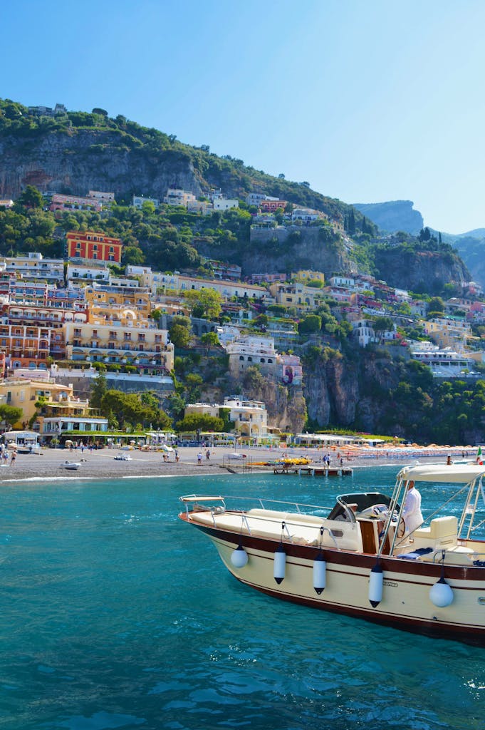 Explore the vibrant cliffs of Positano with a boat on blue waters, ideal for travel bliss.