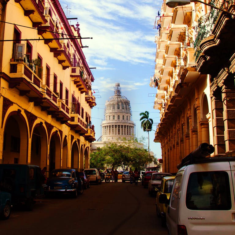 Picturesque Havana street with classic cars and a view of the Capitolio.