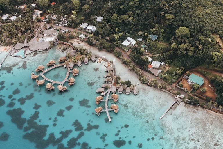 Stunning aerial shot of turquoise waters and overwater bungalows in French Polynesia.