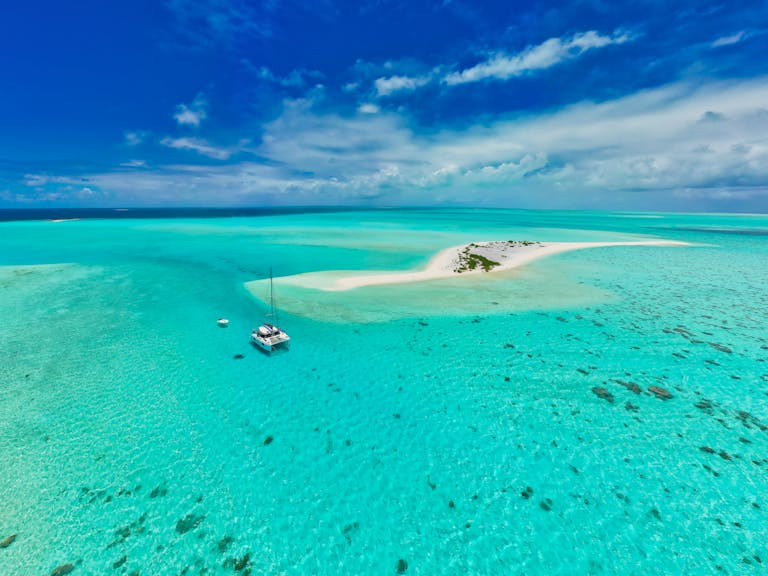 Stunning aerial view of a sailboat near a pristine sandbar in Mauritius' turquoise waters.