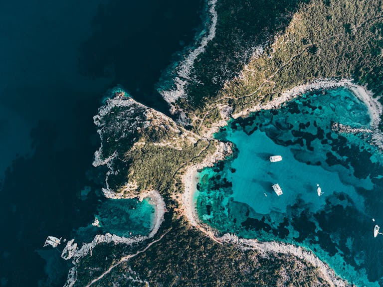 Stunning aerial view of Kerkira coastline with clear turquoise waters and yachts in Corfu, Greece.