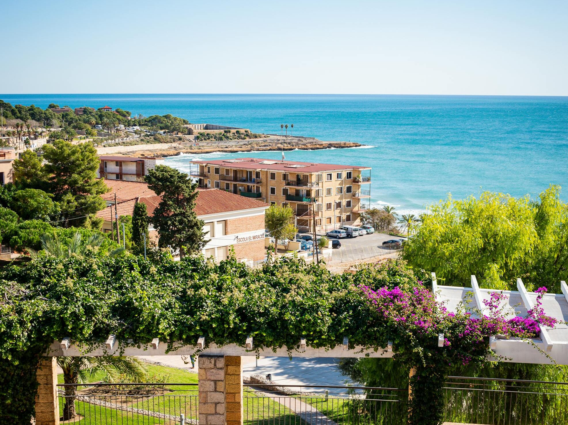 Explore Tarragona's vibrant seascape with Mediterranean architecture and lush greenery.