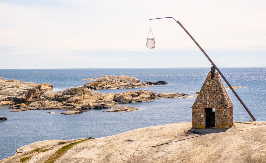 Scenic view of rocky coastline and iconic lighthouse at Verdens Ende, Norway.