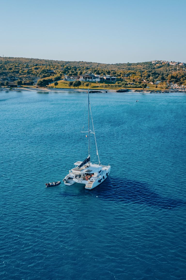 Stunning aerial shot of a yacht in the serene waters of Çeşme, Izmir, Turkey.